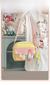Détail du sac bandoulière patchwork coloré avec breloque lune en peluche et logo