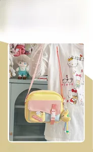 Détail du sac à bandoulière coloré avec breloque lune et sangle ajustable