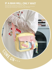 Détail du sac bandoulière en toile multicolore avec sangle rose et fermeture à boucle