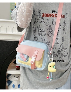 Détail du sac bandoulière en nylon coloré avec boucle et charm lune en peluche douce
