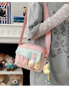 Détail du sac bandoulière en toile colorée avec sangle rose et pendentif lune en peluche