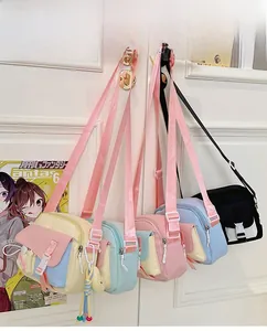Détail de divers sacs bandoulière en nylon couleur bonbon suspendus à une poignée
