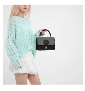 Dettaglio borsa patchwork in pelle nera e tessuto con chiusura dorata e logo fashion