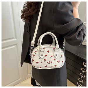 Mini crossbody bag featuring a sweet red cherry print on white leather with handle