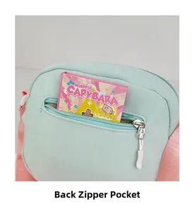 Détail d'un sac bandoulière vert montrant la poche zippée cachée au dos et la sangle rose