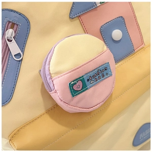 Detailed close-up of a colorful canvas shoulder bag with house patterns and coin pouch