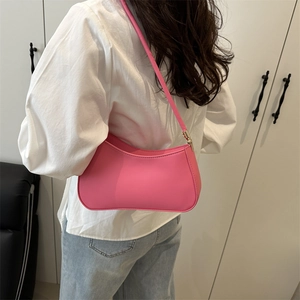 Sac à bandoulière baguette rose minimaliste porté par un mannequin pour le quotidien