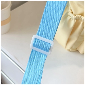 Detail of adjustable light blue nylon strap and white buckle on minimalist tote bag
