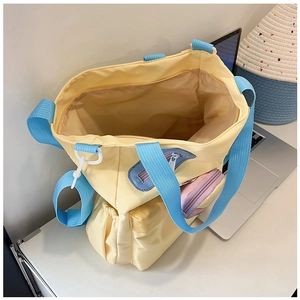 Detail of canvas tote bag with zipper pockets, side pouch and pink coin purse attachment