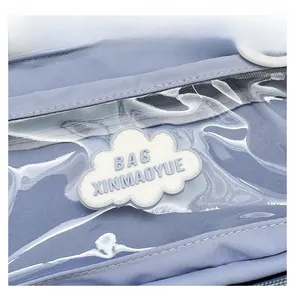 Detail of light blue canvas bag with transparent PVC pocket and cloud badge ornament