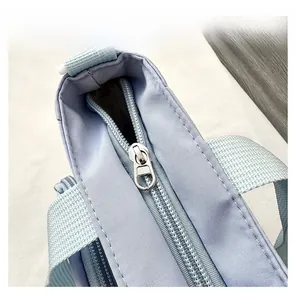 Detail display of the smooth metal zipper and neat stitching on light blue tote bag