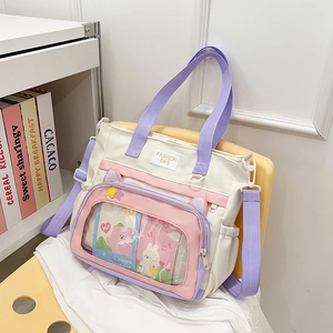 Chic multi-color canvas tote bag with transparent front pocket on a yellow chair