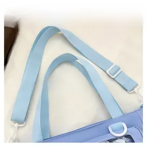 Detail view of woven light blue shoulder strap with durable white adjustable buckles