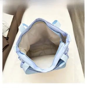 Detailed top view of light blue tote bag interior with zipper and white lining