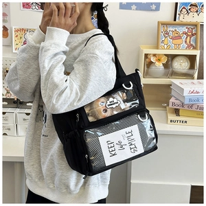 Detail of black canvas ita bag with dual clear PVC display windows and plush doll