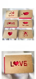 Detail of kraft paper laser-cut greeting cards with heart patterns and red liners