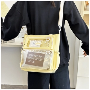 Detail of light yellow crossbody bag featuring double clear pockets and nylon texture