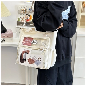 Detail of crossbody bag with transparent windows featuring decorative cards and cloud patch
