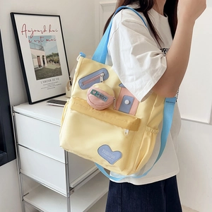 Cute yellow cow print tote bag with blue heart patch and pink coin purse charm for students