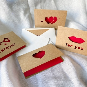 Laser-cut kraft paper thank you cards with red liners, envelopes, and heart designs