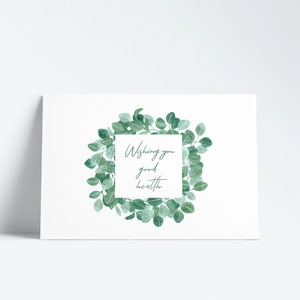 Detail view of a white greeting card with eucalyptus wreath and good health wishes text