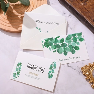 Botanical greeting cards with eucalyptus patterns and envelopes on a marble surface