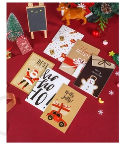 Flat lay of 6 creative Christmas cards with envelopes and stickers on a festive red background