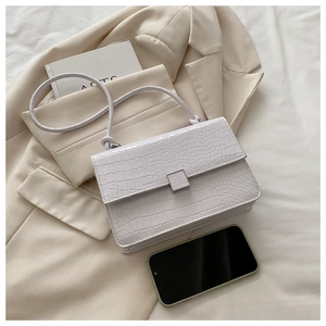 Close-up of minimalist lavender faux-crocodile skin handbag with square metal clasp detail