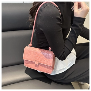 Pink croc-embossed flap shoulder bag shown on model for daily commuting style