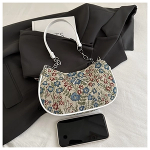 Détail du sac cabas en jacquard floral avec nœud argenté et bandoulière chaîne