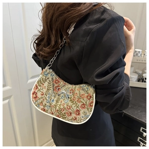 Detail of floral jacquard tote bag with silver bow accent and metal chain strap