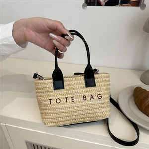 Woven straw tote bag with black TOTE BAG embroidery and adjustable shoulder strap