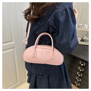 Pink minimalist leather pillow bag with adjustable straps shown in a lifestyle home setting