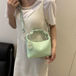 Mint green pleated handle crossbody bag with gold metal hooks and adjustable strap