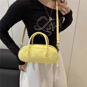 Glossy bright yellow cylindrical baguette bag with top handles and adjustable strap