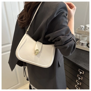 White leather shoulder bag with gold ring buckle worn by a model in a black suit