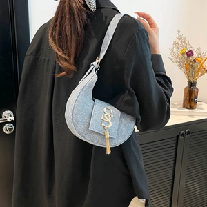Sac à bandoulière croissant en jean bleu clair avec boucle S dorée et pompon