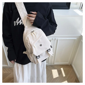 Detailed view of cream nylon crossbody chest bag with adjustable strap and buckle closure