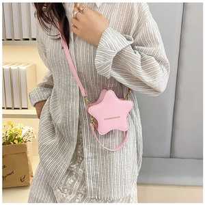 Close-up of pink star-shaped crossbody bag with gold fashion text and fine stitching