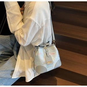 Detail of light blue bucket bag with colorful wavy embroidery and leather drawstring