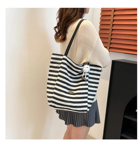 Détail du sac cabas rayé en toile avec patch en cuir et pendentif en peluche