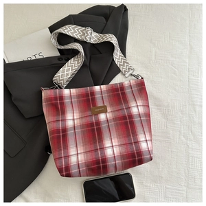 Detail of red and white checkered canvas tote with patterned wide strap and fashion label