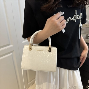 Chic cream snakeskin texture handbag with woven handles and gold fashion engraving