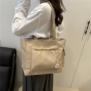 Minimalist beige nylon tote bag with front zipper pocket and large capacity for daily commute