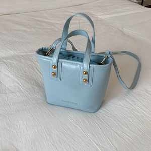 Light blue patent leather tote bag with gold rivets and detachable shoulder strap