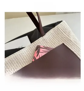 Detail of woven tote bag featuring a leather pocket with an embossed bear and logo