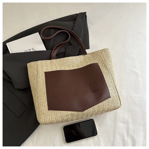Detailed straw tote bag texture with brown PU leather bear pocket on flat lay background