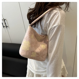 Close-up of pink floral jacquard fabric texture on a stylish underarm shoulder bag