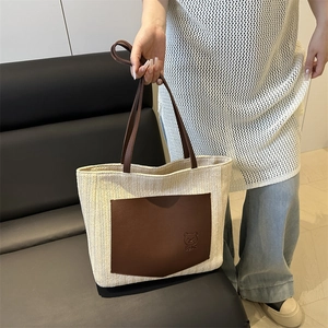 Large straw tote bag with brown leather trim and cute bear print for summer outfits