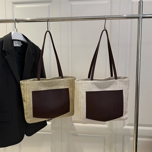 Large woven straw tote bag with brown bear embossed leather pocket in beige tones